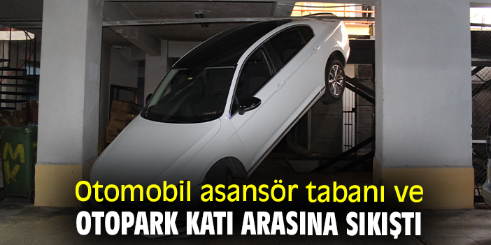 Otomobil asansör tabanı ve otopark katı arasına sıkıştı